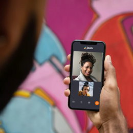 Someone holding a smart phone to connect virtually with a mental health provider