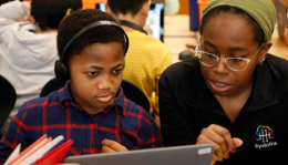 SPS student using a laptop with an adult mentor