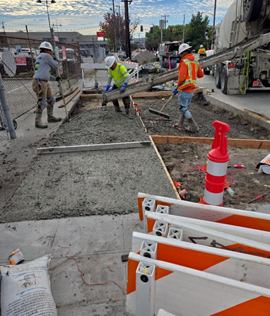 Crews pour a new driveway for a parking lot across from local businesses near NW Dock Pl on Leary Ave NW