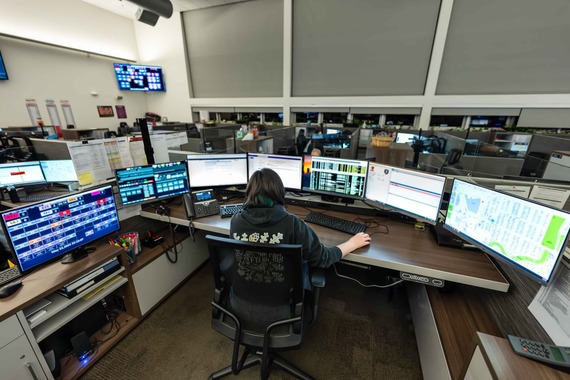 9-1-1 dispatcher seated at desk and viewing computer monitors