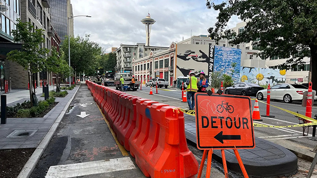 A street under construction with the Space Needle in the background