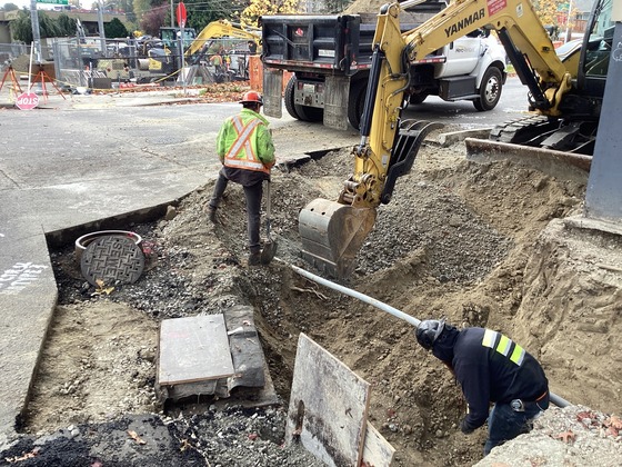 Photo showing crews working on installing underground conduits along west side of Rainier Ave S at S College St.