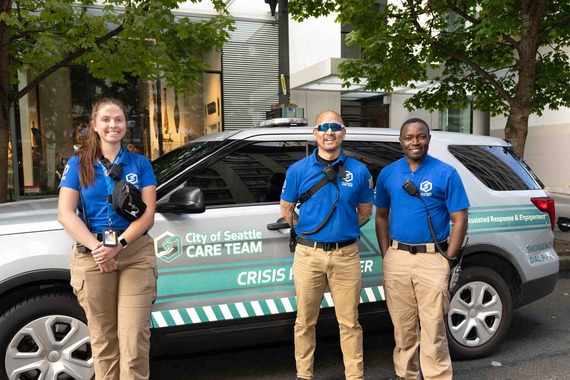 Three CARE community crisis responders standing in front of CARE responder vehicle