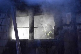 Firefighter putting water on a fire in a commercial building in the 2800 block of South Massachusetts Street