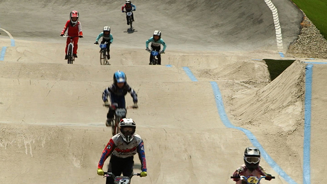 Youth ride bikes on a BMX track