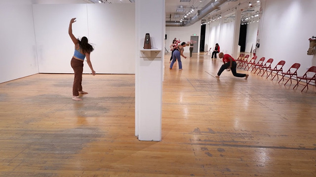 Students dance by themselves in different spaces in art gallery