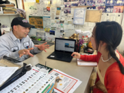 Asian woman talking to boy using laptop