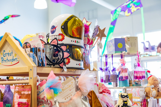 Inside the Clover Toys shop. An assortment of toys sit on top of a wooden shelf.