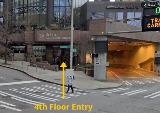 Photograph of the intersection at 4th Ave and Columbia Street with an arrow pointing to the building entrance.