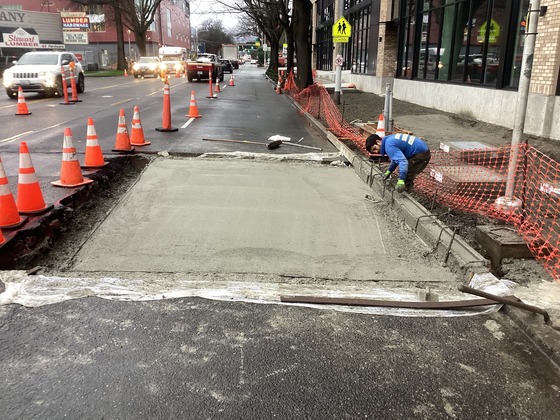 Crews poured concrete to pave back the east side of Rainier Ave S at S Grand St.