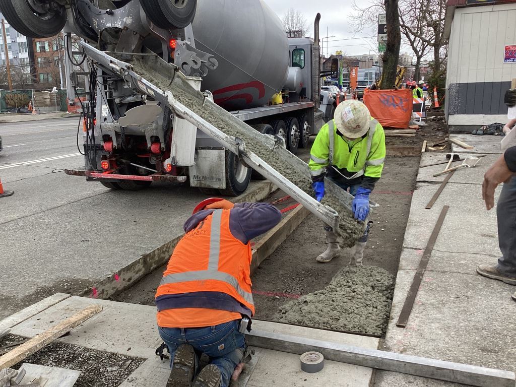 Crews pour new sidewalks on the east side of 15th Ave NW between NW 50th St and NW 51st St