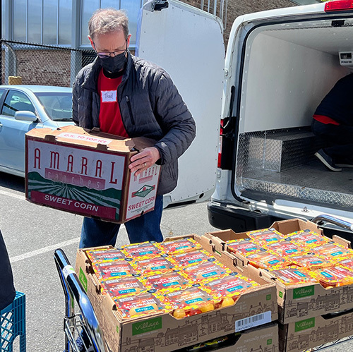A person unloading a box of food from the back of a van