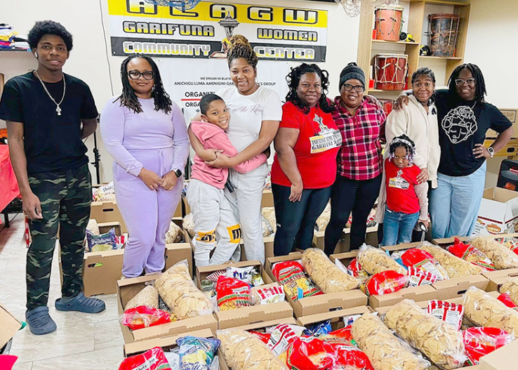 Group of people stand around bags of food