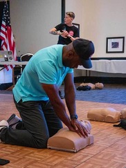 CPR instructor demonstrating chest compressions during a class.
