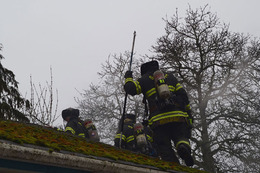 Firefighters on the roof of a building on fire in the 8100 block of 16th Avenue Southwest