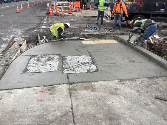 Crews constructing ADA curb ramp at Rainier Ave S and S Grand St.