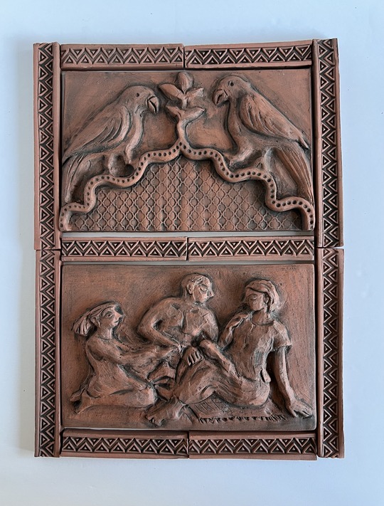 A terracotta relief carving of two birds and three people