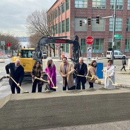 A group of people using shovels for ceremonial ground breaking on Bell street