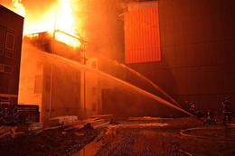 Firefighters put water on a building fire