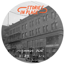A black and white photo of a brick building with an orange logo that says "Stories in Place."