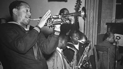 A black and white vintage photo of a person playing a trumpet