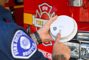 Firefighter testing a smoke alarm