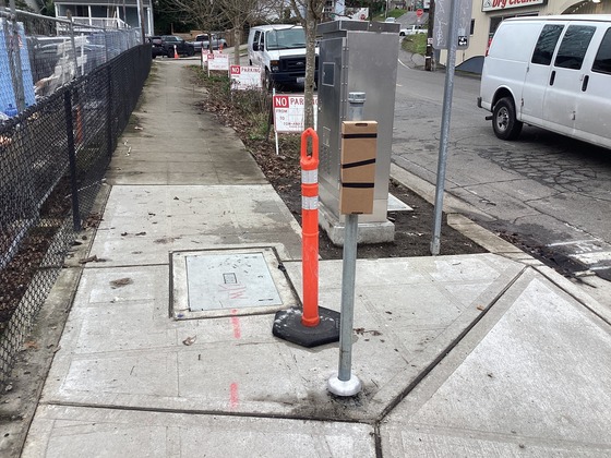 Newly installed ADA curb ramp, signal controller cabinet, and pedestrian push button at the southwest corner of Rainier Ave S and S College St.