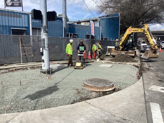 Photo showing crews preparing sidewalk corner for concrete pour.