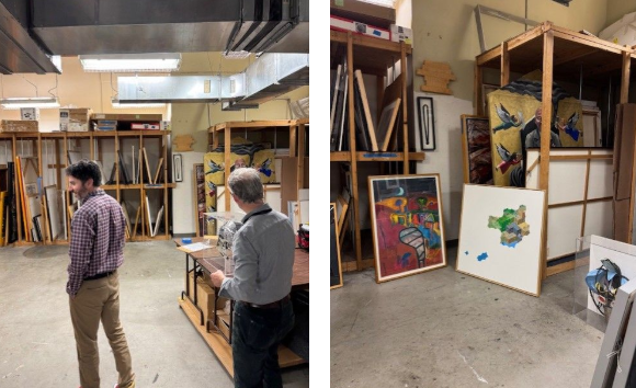 OPA staff in the City's art warehouse looking at framed artwork on wooden shelves.