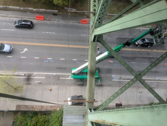 Crews use a lift from S Dearborn St to install scaffolding under the Dr. José Rizal Bridge, temporarily impacting lanes and the north sidewalk.