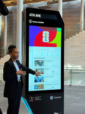 A person demonstrating how to use the new digital kiosk