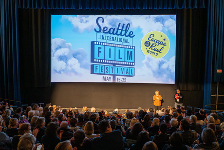 Seattle International Film Festival event with an audience, presenters, and a screen displaying festival details.