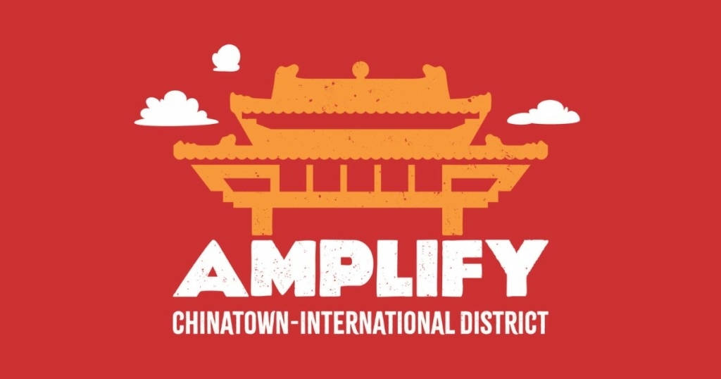 A gold torii on a red background with white words "Amplify Chinatown-International District" 
