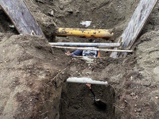 A crew member digs beneath utilities on Fairview Ave N. 