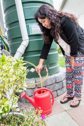 Stormwater cistern woman filling watering can