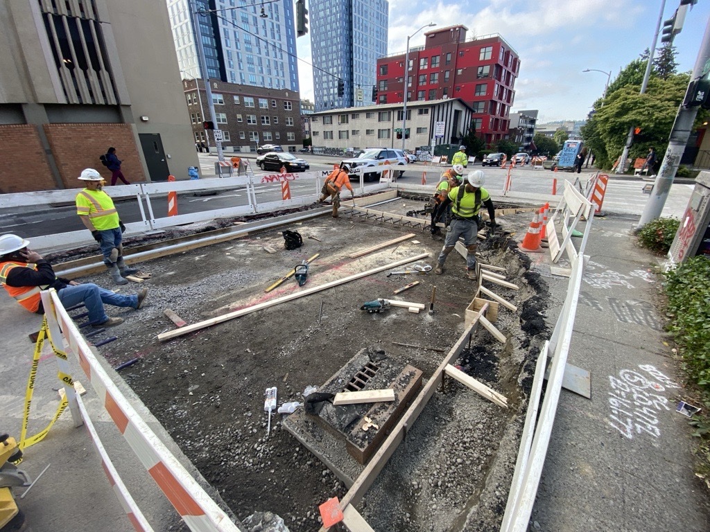 Crews work on the road at the intersection of NE 43rd St and 11th Ave NE. 