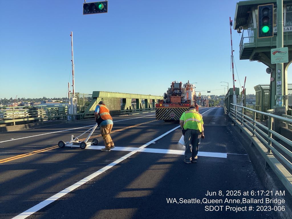 Crews add permanent pavement markings on the Ballard Bridge.