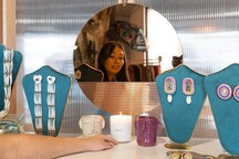 Tidelands owner facing mirror with jewelry and candles on counter