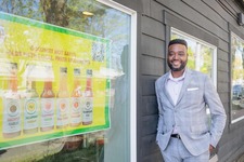 Papa Tony’s owner in front of hot sauces poster