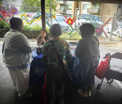 OPA Complaint Navigator chatting at a table with community members