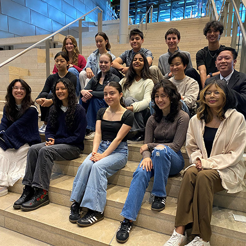 A group of 15 teenagers sitting on a grand staircase