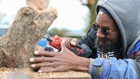 Close up of a person carving a wood sculpture