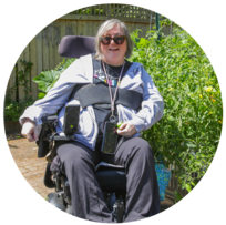 A person sitting in an electric wheelchair in a community garden