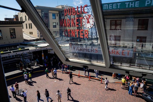 Aerial view of the Pike Place Market sign with people walking around below