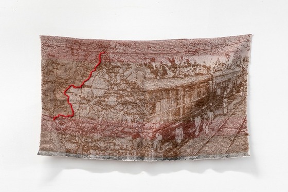 Fabric artwork with imagery of a train and a map on India and Pakistan with the partition line outlined in red