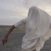 Still from There Were Those video of a person wrapped in a billowing white cloth