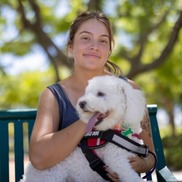 A young person holding a service dog.