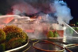 Firefighters put water on a funeral home building fire.