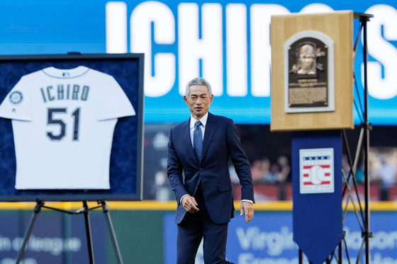 Ichiro next to his jersey and Hall of Fame plaque during a pregame ceremony to retire his number