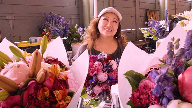 Lue Thao holds flowers at Pike Place Market